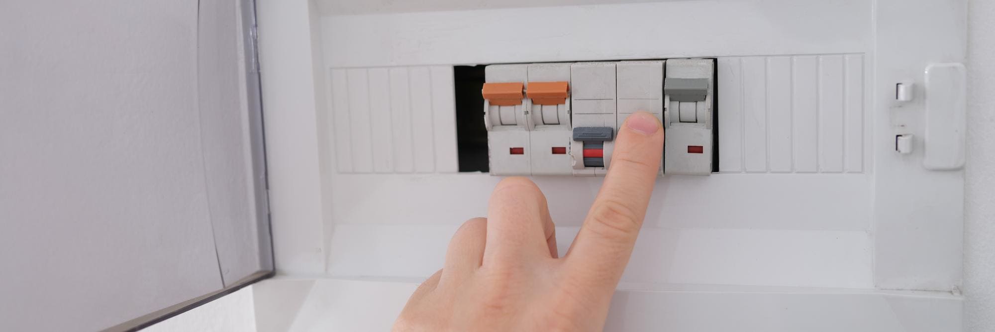 Interruptor diferencial eléctrico siendo accionado para cortar el suministro eléctrico y garantizar la seguridad en el hogar